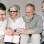 Happy family exchanging gifts together, capturing a joyful moment indoors.