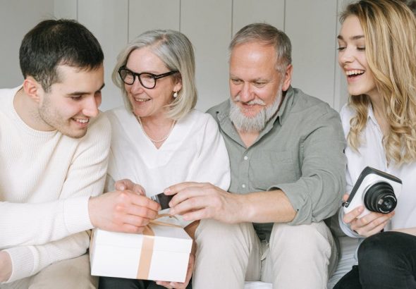 Happy family exchanging gifts together, capturing a joyful moment indoors.